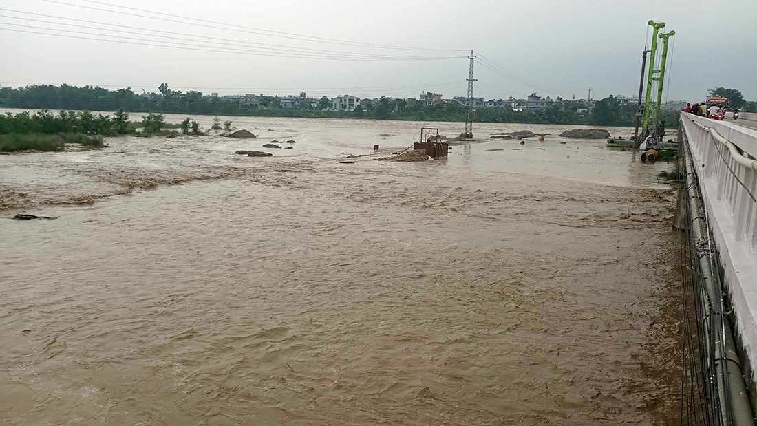 दमकको रतुवा नदीमा आएको बाढीले डुबानमा परेका  निर्माण उपकरणहरु । सोमबार बिहान नदीमा आएको बाढीले पुल निर्माणमा प्रयोग भईरहेको तीन वटा ठुला उपकरण डुबानमा परेको छ । तस्बिर ः  यज्ञराज आङदेम्बे / रासस